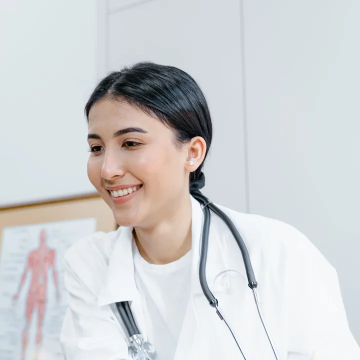 Bác sĩ nữ mỉm cười ghi chép bên bàn làm việc