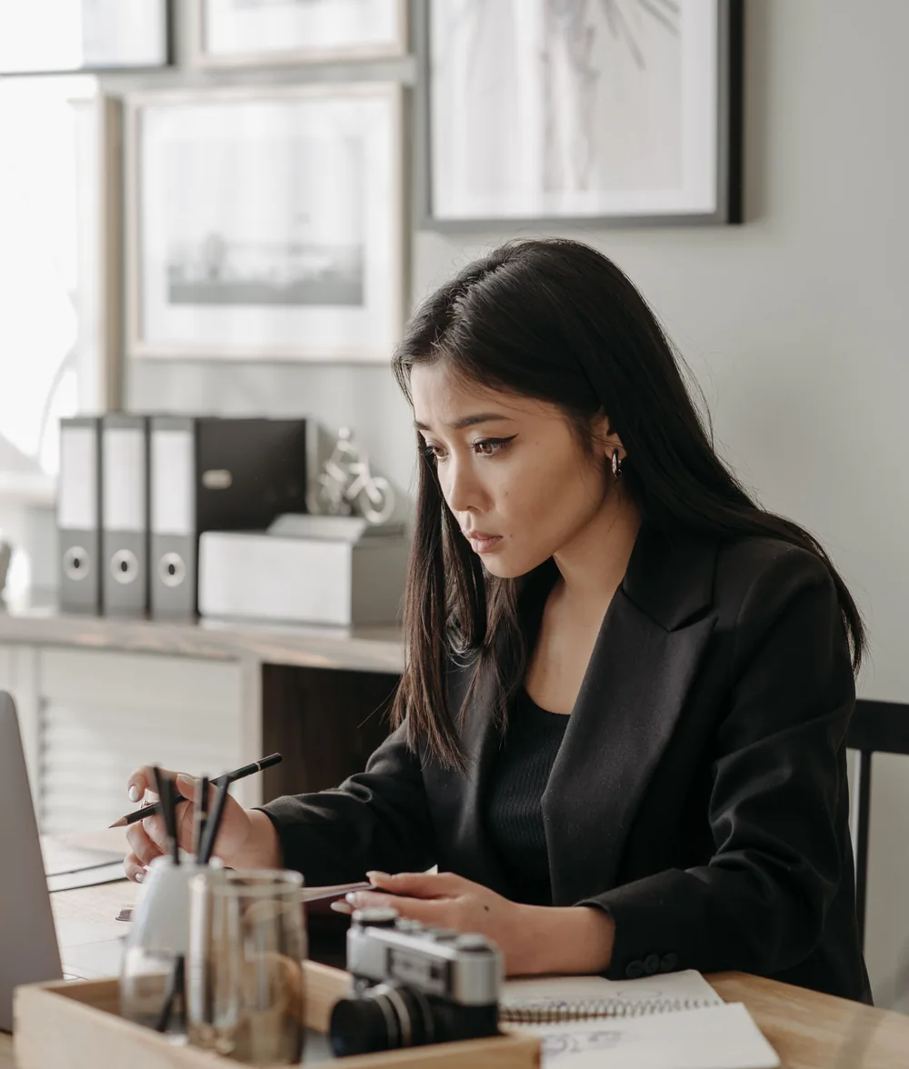 Người phụ nữ ngồi làm việc bên bàn giấy